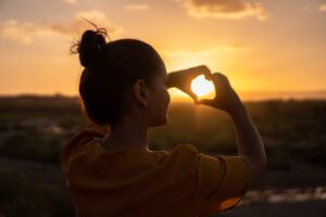 Gefühl symbolisiert durch ein Herz woman doing hand heart sign